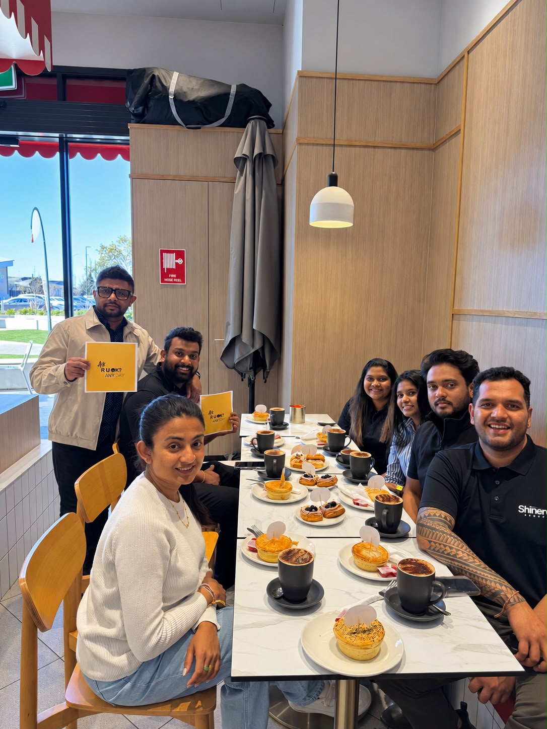 Team members sharing coffee and conversation for R U OK Day