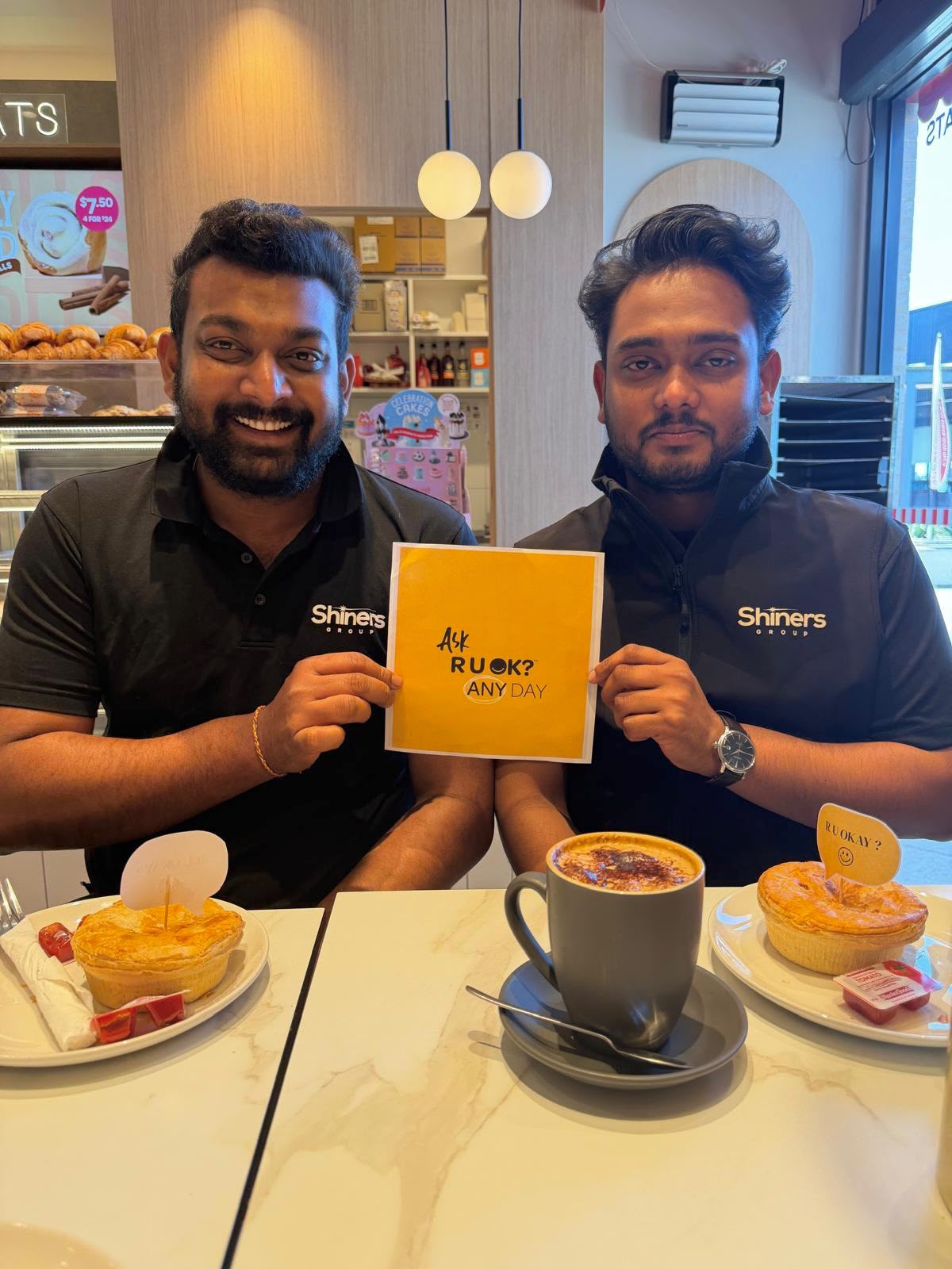 Team members holding an Ask R U OK? Any Day sign