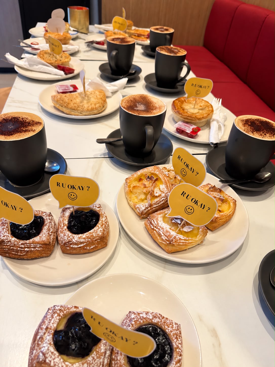 A table of R U OK? themed pastries and coffee